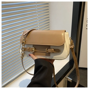 Close-up of cream and khaki contrast crossbody bag with gold chain strap detail