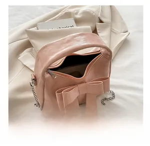 Inside view of a pink bow handbag showing interior storage and zip closure detail