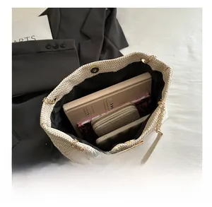 Detail view of woven straw tote bag with magnetic clasp showing spacious storage capacity