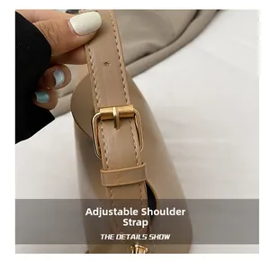 Detail of adjustable shoulder strap with gold-tone buckle on beige minimalist handbag