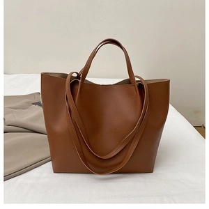 Detail of caramel leather tote bag showing smooth texture and versatile dual strap design