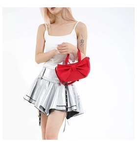 Détail du sac à main rouge en nylon en forme de nœud avec jupe argentée au style Y2K