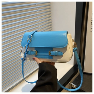 Detail of color-block crossbody bag in blue and beige with golden metal hardware