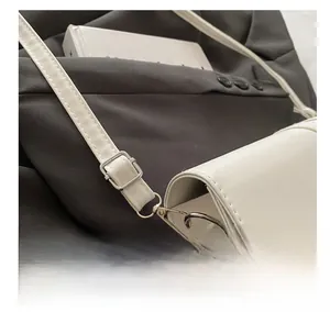 Detail of adjustable PU leather shoulder strap with silver buckle and fine stitching