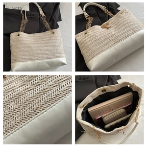 Macro view of woven straw tote with leather handles, gold chain, and spacious interior