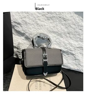 Detail of minimalist black leather and twill fabric bag with unique silver metal handle