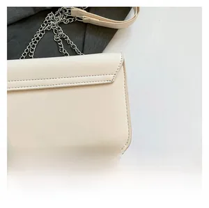 Detailansicht der cremeweißen Ledertasche mit feinen Nähten und silberner Metallkette