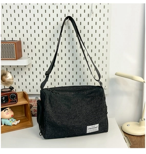 Détails du sac bandoulière noir avec sangle réglable et plusieurs poches zippées de rangement