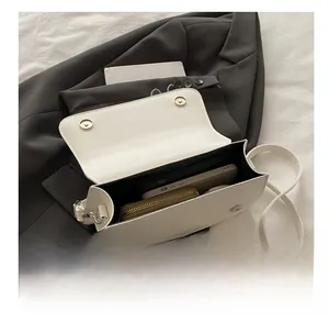 Detailed interior view of white faux leather baguette bag showing storage capacity
