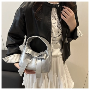Silver bow shoulder bag showing the metallic finish and dual-use chain strap style