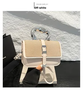 Detail of off-white crossbody bag with silver liquid metal handle and heart buckle charm