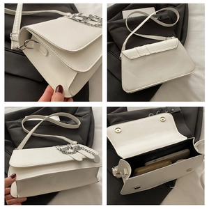 Detail view of stylish white crossbody bag showing metal chain and internal storage capacity