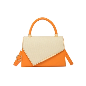 Chic orange and beige patchwork crossbody bag with round handle and gold trim details