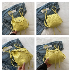 Detailansicht des gelben gesteppten Mini-Rucksacks mit Herznaht und Kettenriemen