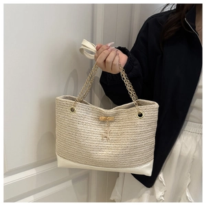 Détail du sac cabas en paille tressée crème avec chaîne dorée et pendentif cerf