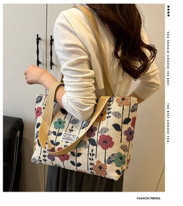 Shoulder shot of a large floral canvas tote bag with khaki straps in a modern interior