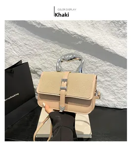 Detail of khaki leather handbag with unique silver metal handle and buckle decoration
