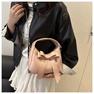 Détail du sac bandoulière rose en cuir PU avec nœud décoratif et chaîne en métal