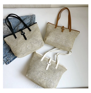 Détail de trois sacs cabas en paille tissée avec finitions en cuir noir, marron et blanc