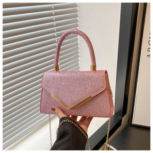Close-up of pink sequined crossbody bag featuring golden V-shaped metal hardware and chain