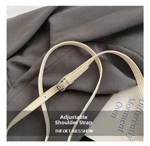 Detail of adjustable litchi texture leather shoulder strap with silver metal buckle