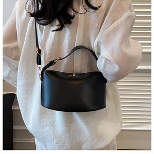 Detail der minimalistischen schwarzen Leder-Eimertasche mit goldener Schnalle und Gurt