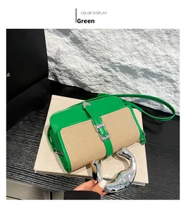 Detailed shot of green crossbody bag with textured panel and oversized silver metal handle