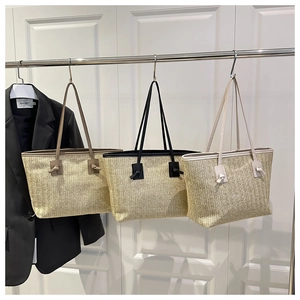 Detailed close-up of straw woven tote bags in brown, black and white color options