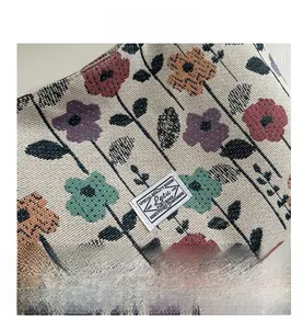Close-up of jacquard knit fabric featuring a vintage floral pattern and woven brand label