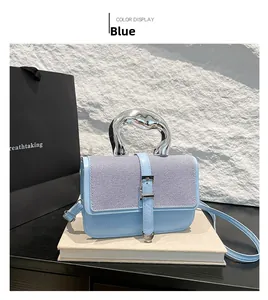 Detail view of blue tweed patchwork bag with silver lava-style handle and strap