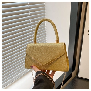 Detail of a golden sequin evening handbag featuring a V-shaped metal clip and chain