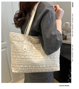 Detailed view of cream lace tote bag with leather logo patch and sturdy shoulder straps