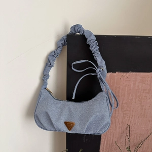 Light blue striped denim underarm bag with a scrunchie strap and metal logo