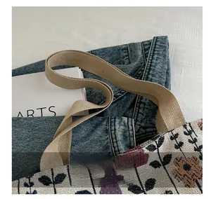 Close-up of floral print canvas tote bag with woven handles and vintage plant pattern