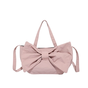 Sac à bandoulière rose pâle avec nœud décoratif et texture plissée élégante