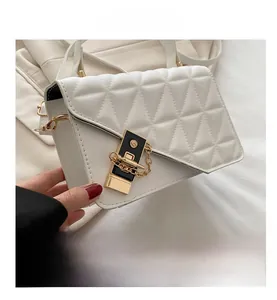 Close-up of white quilted leather texture and gold metal clasp with S-letter logo