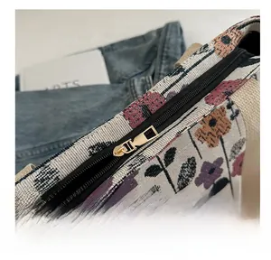Close-up of smooth gold metal zipper on floral canvas tote bag with detailed fabric texture