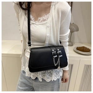 Detail of black matte leather baguette bag with silver chain and belt buckle decor