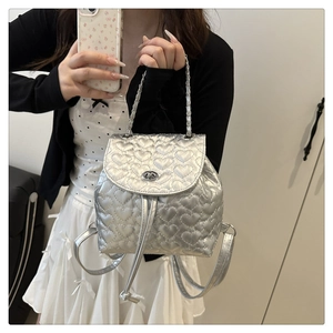 Detail des silbernen Rucksacks mit Herzsteppung, Metallic-Finish und Drehverschluss
