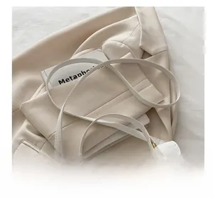 Close-up of white quilted PU leather handbag with gold hardware and adjustable strap