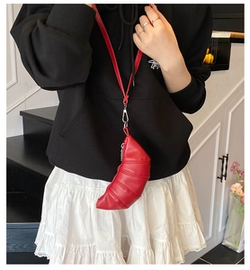 Detail der roten Crossbody-Tasche aus PU-Leder mit gesteppter Struktur in Croissant-Form