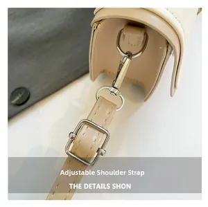 Detail of adjustable cream shoulder strap with silver-tone metal buckle on crossbody bag