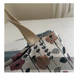 Close-up of woven shoulder bag featuring colorful floral embroidery and neat stitching