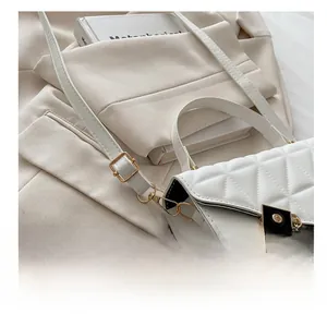 Detail of white quilted crossbody bag showing gold buckle and elegant chain strap texture