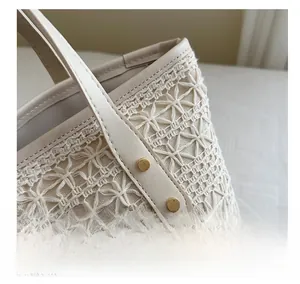 Close-up of woven tote bag showing geometric patterns, leather trim, and metal brand logo