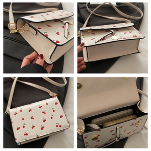Detail view of the interior compartment and cherry pattern on the white crossbody bag
