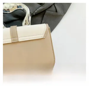 Detail of color-block tote bag featuring silver wavy metal handle and fine stitching