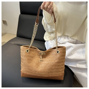 Détails de texture du sac cabas en paille avec pendentif cerf doré et bandoulière en chaîne