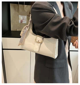 Détail du sac crème embossé crocodile avec boucle dorée et accessoire foulard en soie