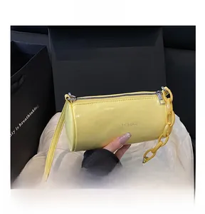 Vue détaillée du sac cylindrique jaune vif avec chaîne en plastique et texte mode